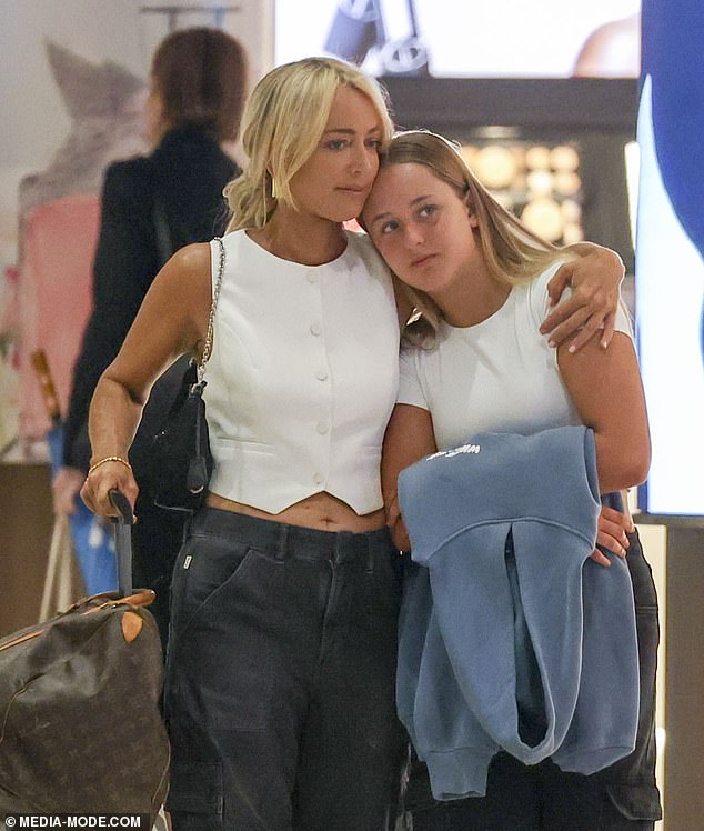The radio star, 49, was seen sweetly cuddling her mini-me daughter, 13, as they strolled through Sydney Airport ahead of their holiday.