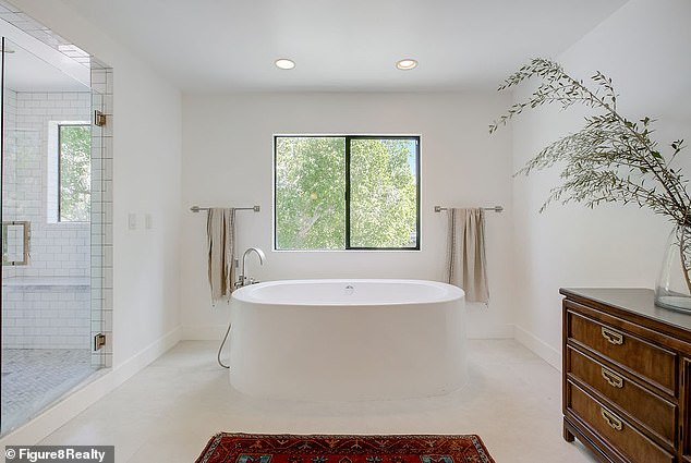 A luxurious en-suite bathtub illuminated by a skylight is also part of the grand master suite wing, upstairs