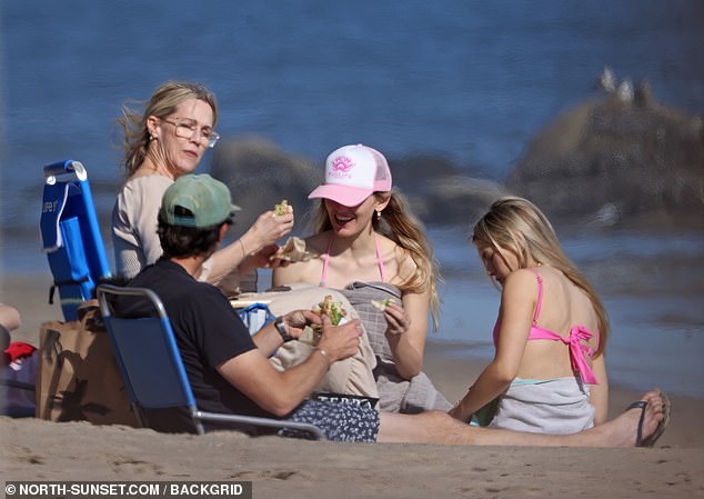 The family seemed to have a great time while sunbathing and enjoying some food on the beach.
