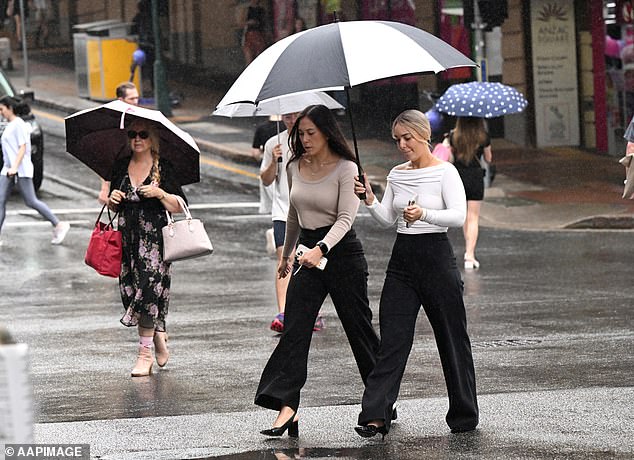 People are seen as it rains in Brisbane's CBD, Friday, April 5, 2024.