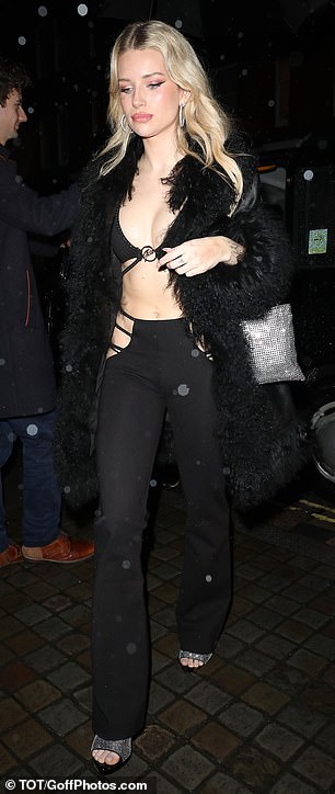 Wrapped in a black faux fur coat, Lottie added height to her frame with a pair of silver open-toe heels.