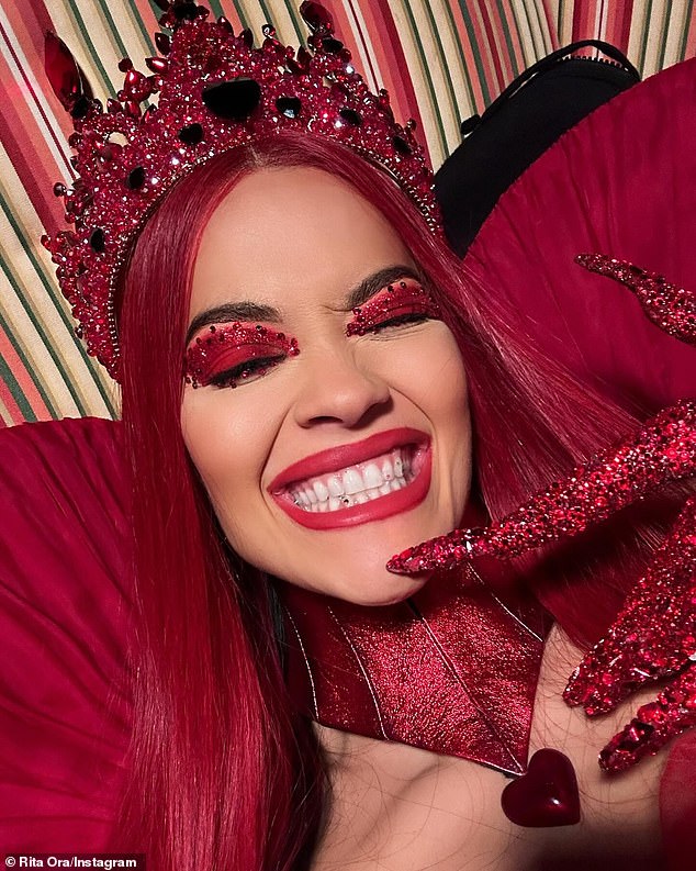 Rita wore red mascara, a long, straight red wig, and a sparkly crown covered in costume jewelry. She let her hair down and flashed a playful smile in some of the Instagram snaps of her.