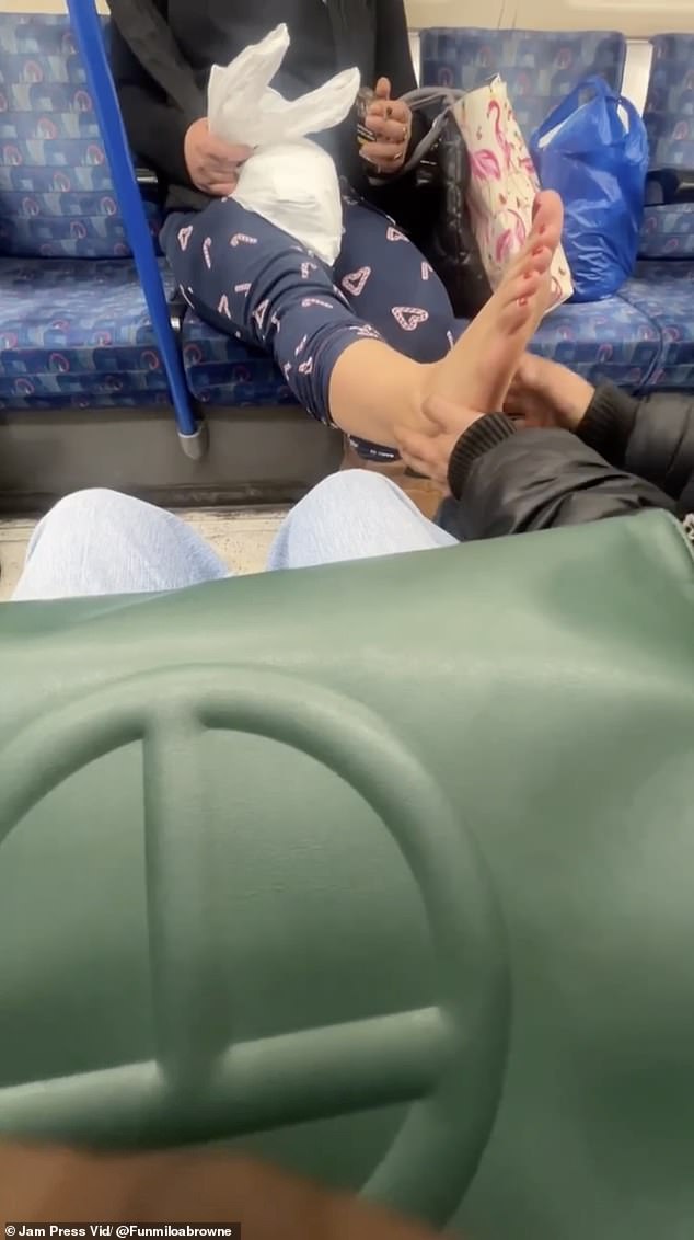 He then begins to caress and rub the soles of his bare feet just millimeters from Lola's legs as the train approaches Euston station.