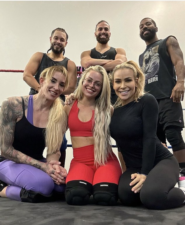Tuft posing for a photo with WWE stars, including former champions Liv Morgan and Natalya.