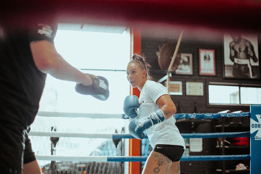 A boxer faces her opponent.