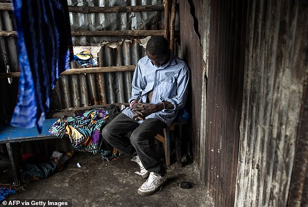 Pictured: A man sleeps inside a drug warehouse at the Kington landfill in Freetown, July 2023.