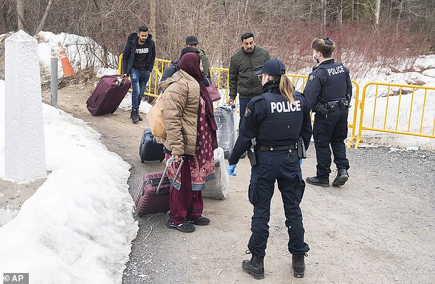 Canadian agents stop asylum seekers as they enter Canada at the Roxham Road entry point with the US.