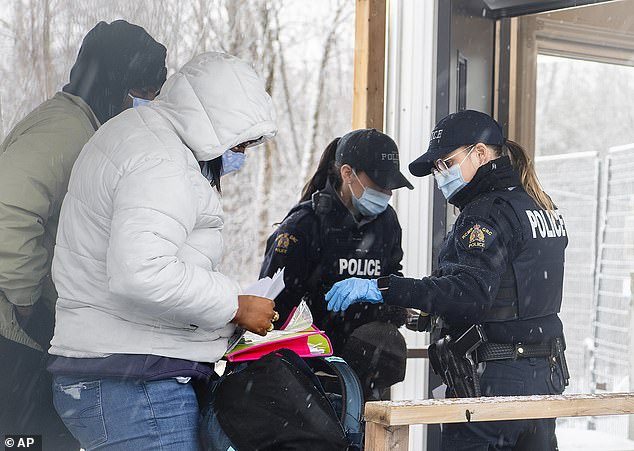 Canadian officials verify the credentials of two people who entered Canada via Roxham Road at the Canada-United States border.