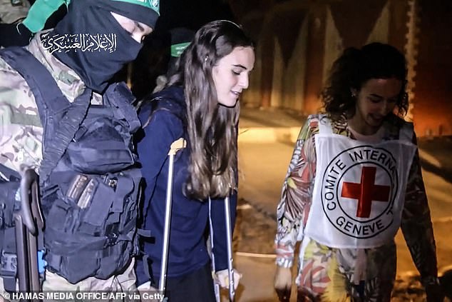 An image taken from a video released by the Hamas Media Office shows a Hamas fighter and a Red Cross doctor accompanying a recently freed Israeli hostage, Maya Regev, to a Red Cross vehicle in the Gaza Strip. Gaza early on November 26, 2023.