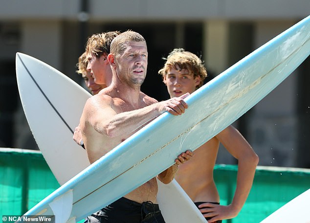 Mick Fanning (pictured front) prepares to jump into the water in tribute to his late brother Ed