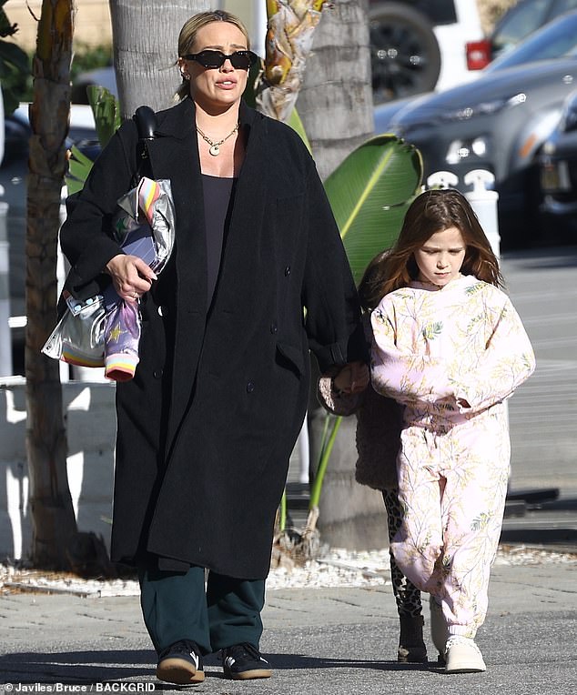 For lunch on Friday, Hilary took her daughters to UOVO Italian Cuisine in Studio City, California, and looked stylish in black sunglasses, green pants, a black stretch top and coat.