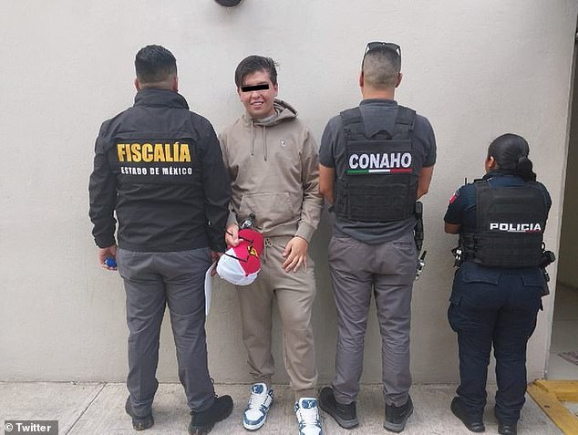 Mexican social media influencer Rodolfo Marquéz, also known as Fofo Marquéz, smiles as he stands with police officers following his arrest Thursday for hitting a female driver on February 22 in the parking lot of a shopping center in Naucalpan, State of Mexico.