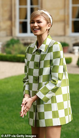 The actress wore a white and green checkered jacket with a high collar while posing in the gardens of the venue.