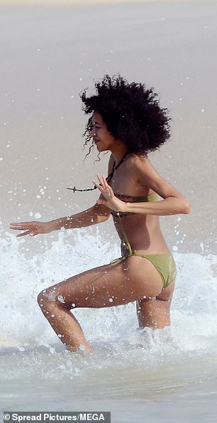 The runway beauty seemed to enjoy splashing around in the warm waters as the waves rolled toward the shore.