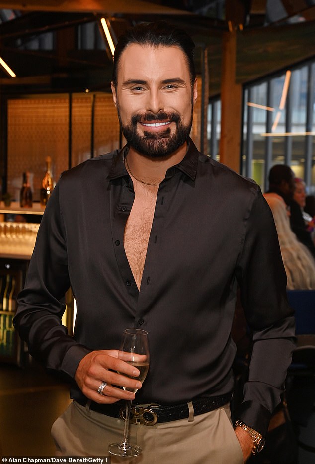 Meanwhile, Rylan caught a glimpse of chest hair in a black shirt he wore partially unbuttoned and beige chinos.
