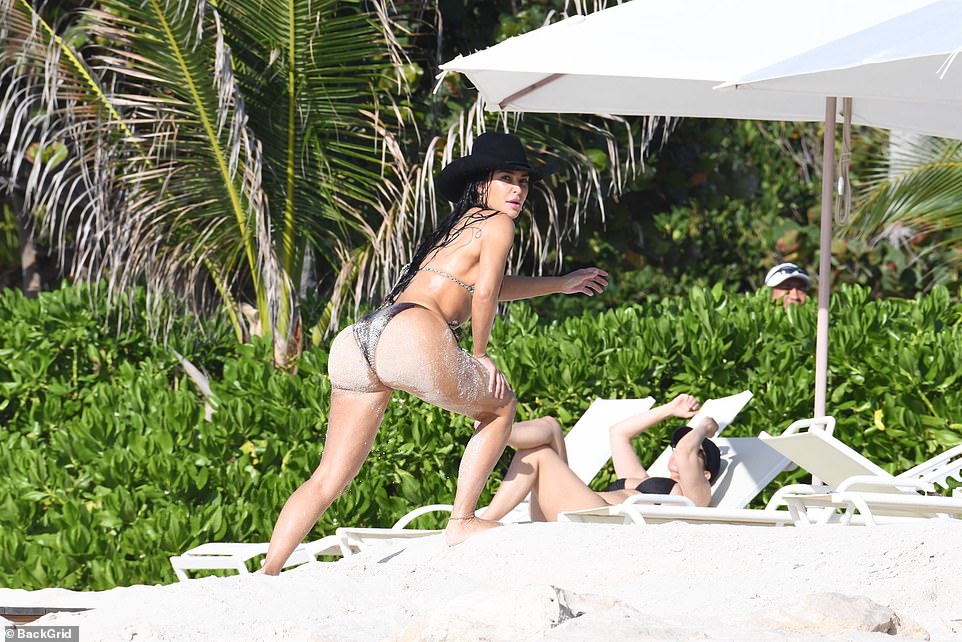 The eldest Kardashian showed off her famous sand-covered behind after taking a dip.