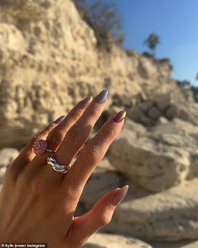 In one photo, she highlighted her iridescent manicure while focusing on one of her sand-covered hands.
