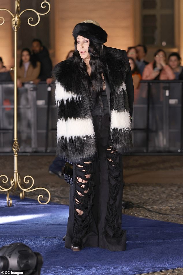 Cher, 77, turned heads in a stunning fur coat and distressed pants.