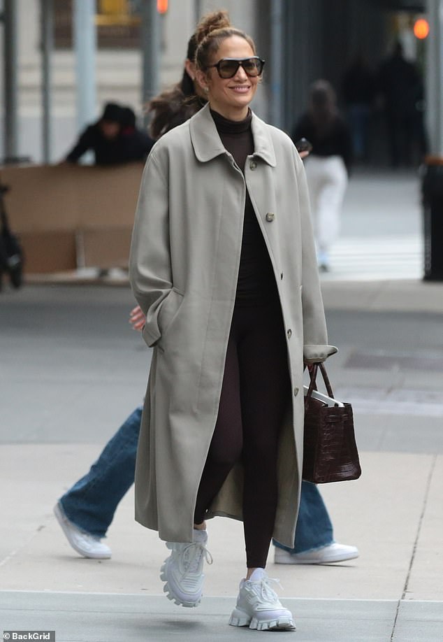 Lopez paired the comfortable outfit with a light gray coat that was left unbuttoned in the front and to help keep her warm in the colder temperatures.