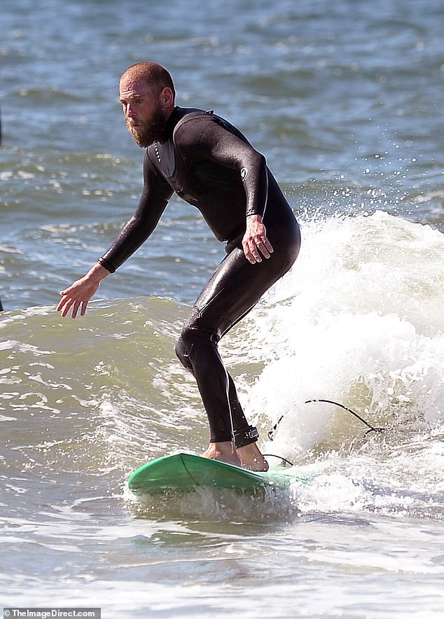 With a tanned look, close-cropped hair and a long, scruffy beard, the mid-'90s writer-director put his impressive surfing skills on display.
