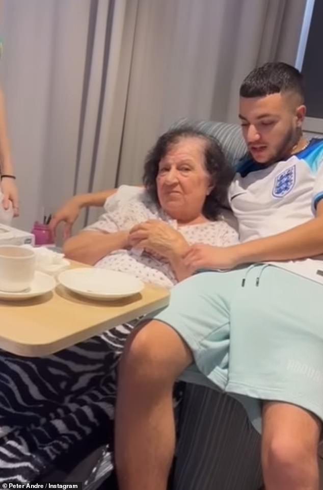 Junior, who cut a casual figure in an England football shirt and shorts, was seen putting his arm around his grandmother as she leaned on her reclining chair.