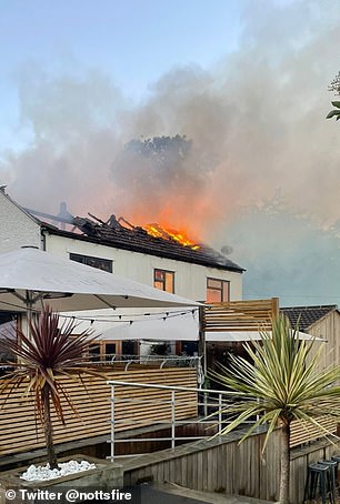 An image of the fire shows the roof severely damaged and smoke billowing