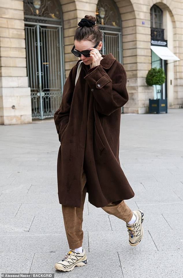 Staying comfortable, the Emily In Paris star rocked a pair of beige sneakers and carried her belongings in a clutch.