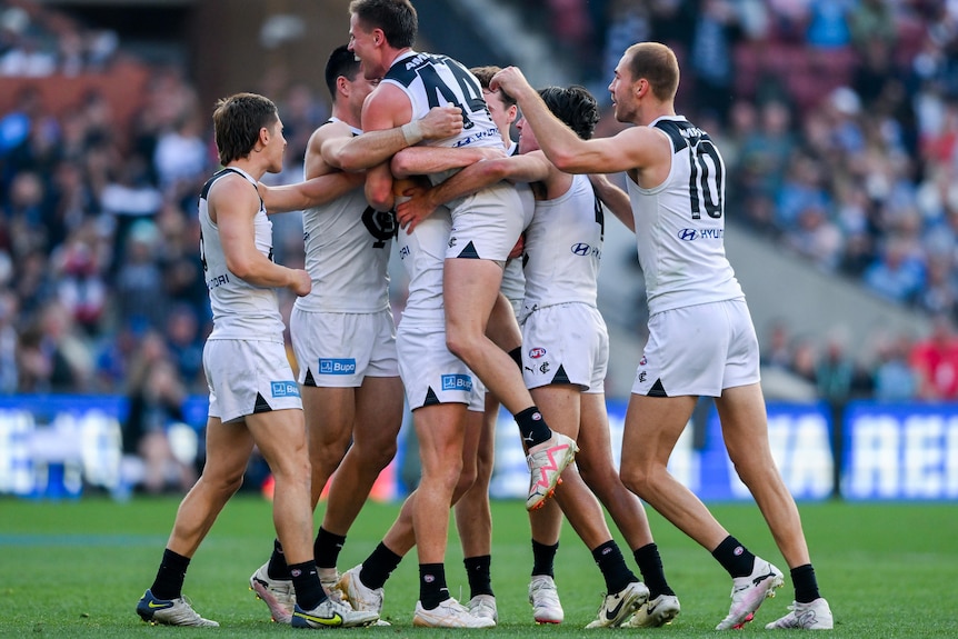 Carlton players celebrate in a large group
