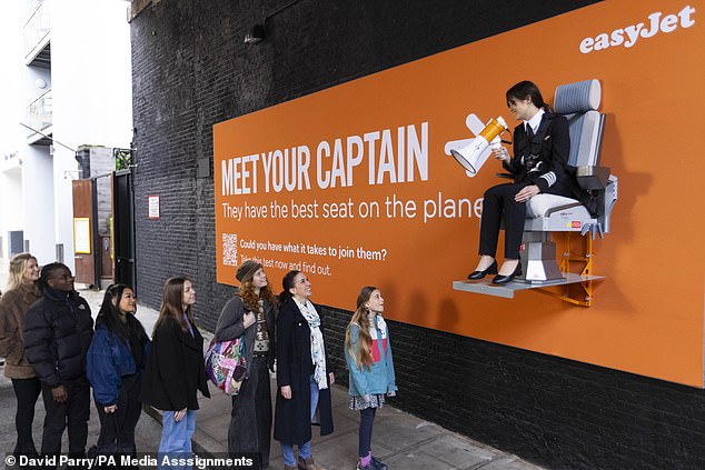 EasyJet pilot Sarah Ackerley sits on a billboard in London last week as her campaign launches.