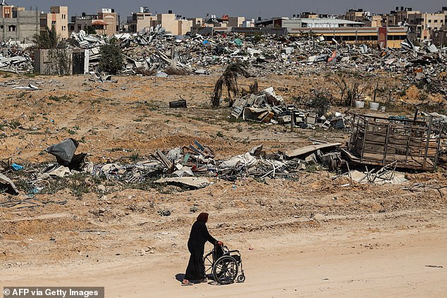 An elderly Palestinian woman pushes a wheelchair through the rubble in Khan Yunis on April 7, 2024 after Israel withdrew troops from the southern Gaza Strip, six months after the devastating war that followed the April 7 attacks. October.