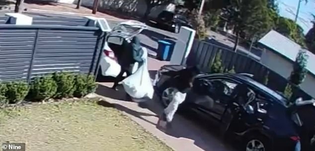 The hooded intruders were seen loading the stolen items into a white car (pictured) before fleeing the scene a short time later.