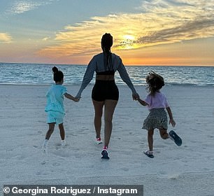 In a sweet snap, Georgina grabbed Alana and Eva's hands as they ran down the beach into the sunset.