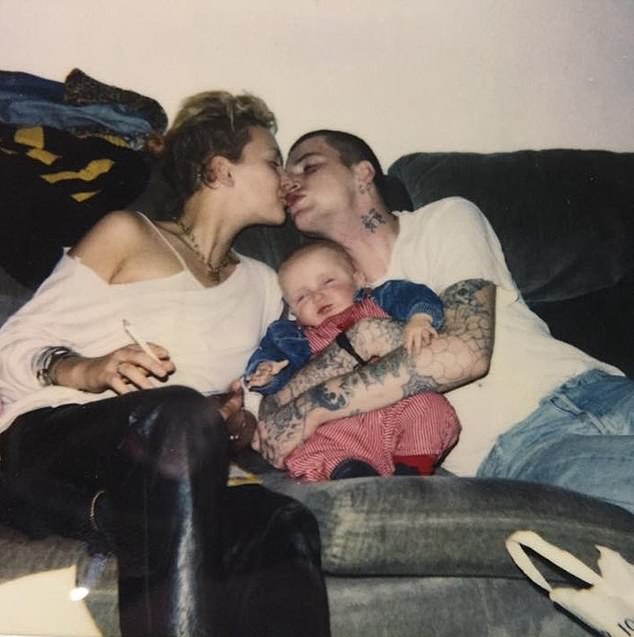 Lady Sitwell has never revealed the identity of her son's heavily tattooed father, who she is pictured kissing, above, with baby Conor on her lap while she holds a cigarette.
