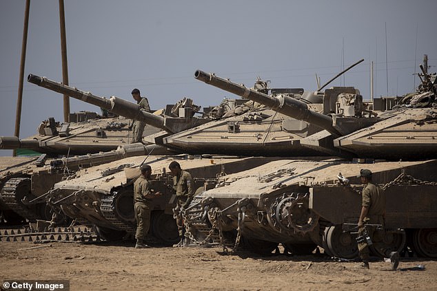 Israeli soldiers organize the equipping of their tanks near the border with the Gaza Strip