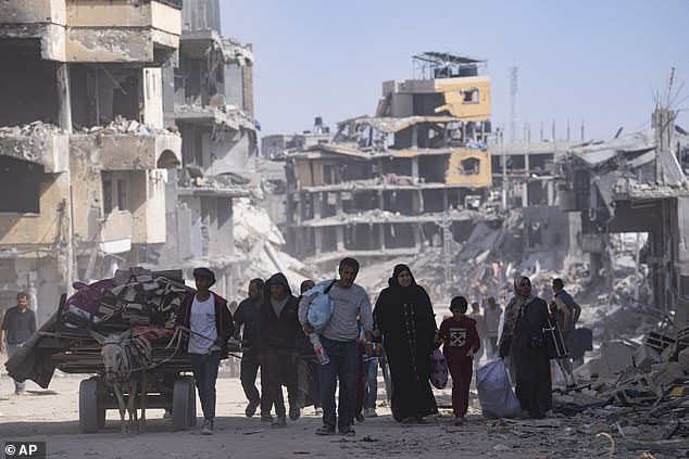 Palestinians walk through the destruction following an Israeli air and ground offensive in Khan Younis.