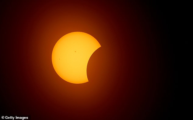 The moon begins to eclipse the sun on April 8, 2024 in Fort Worth, Texas.  Millions of people have flocked to areas of North America that are in the "path of totality" to experience a total solar eclipse.