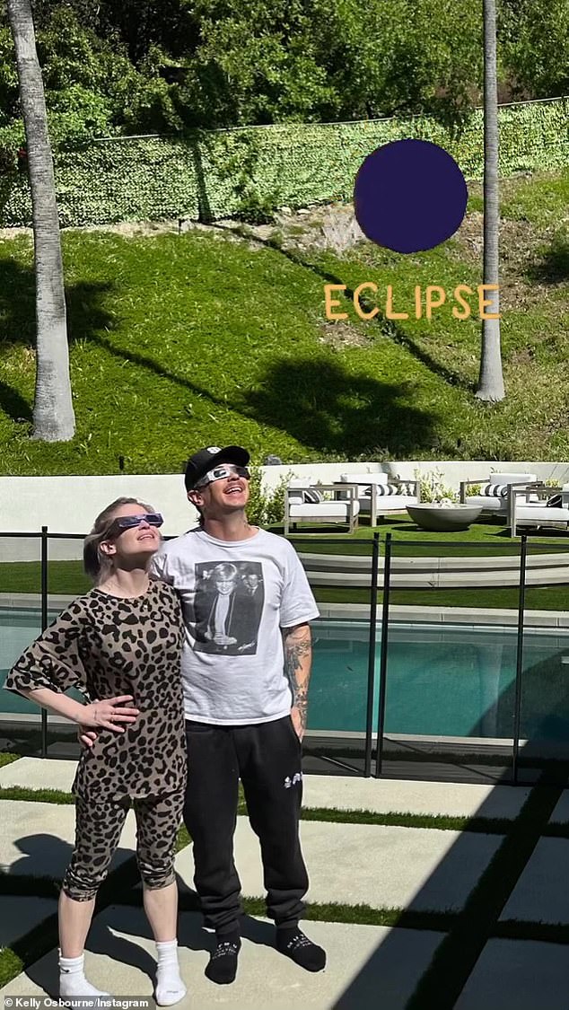 And Osbourne looked stylish in a leopard-print top and capri leggings as she posed in her shades by her pool with her partner Sid Wilson, who was wearing a Princess Diana T-shirt.