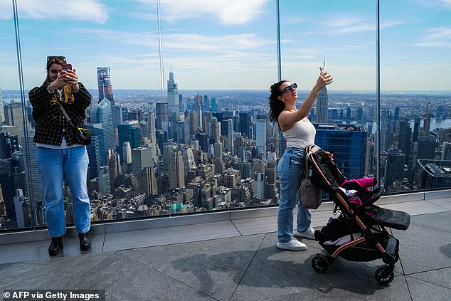 Celestial observers take photographs at 'The Edge' observation deck in New York ahead of Monday afternoon's solar eclipse.