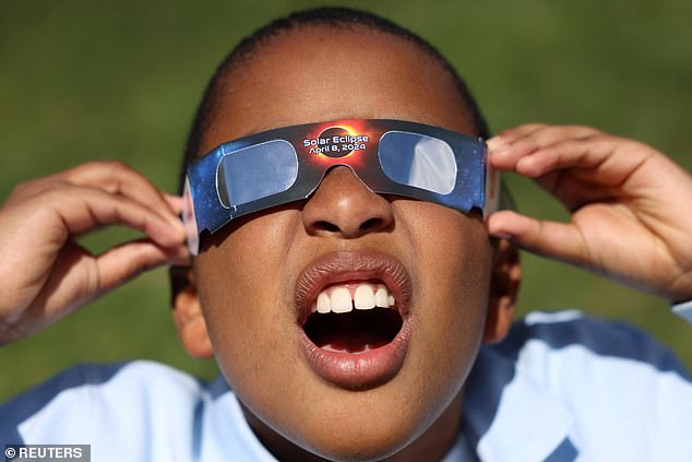 Adrian Plaza, 9, of Queens, tries out his eclipse glasses before a partial solar eclipse, where the moon will partially block the sun, at the New York Hall of Science in the borough of Queens, New York City.