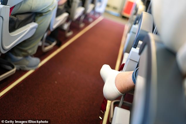 An airplane passenger sits without shoes.
