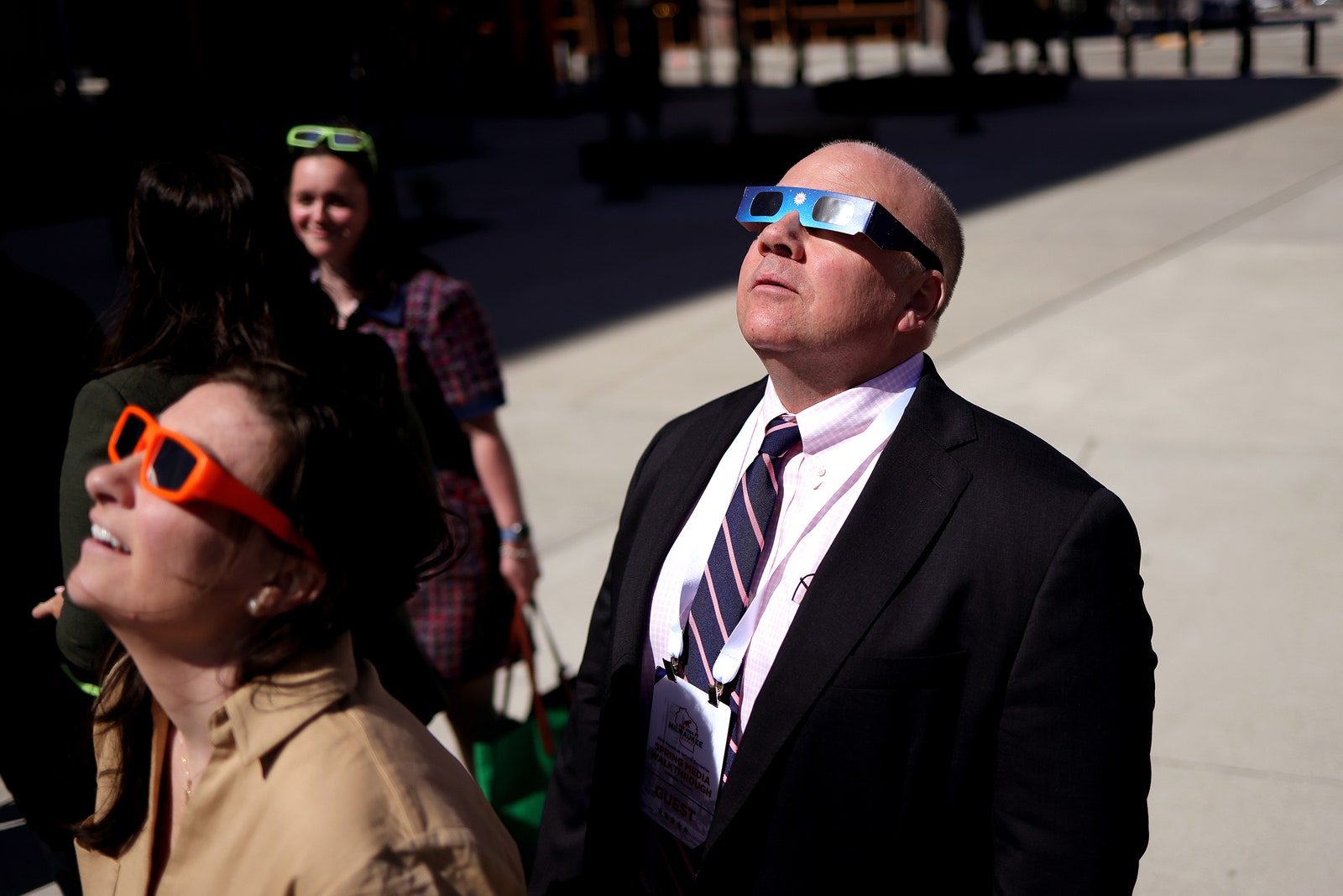 Photo of people admiring the partial solar eclipse outside the Fiserv Forum on April 8, 2024 in Milwaukee, Wisconsin