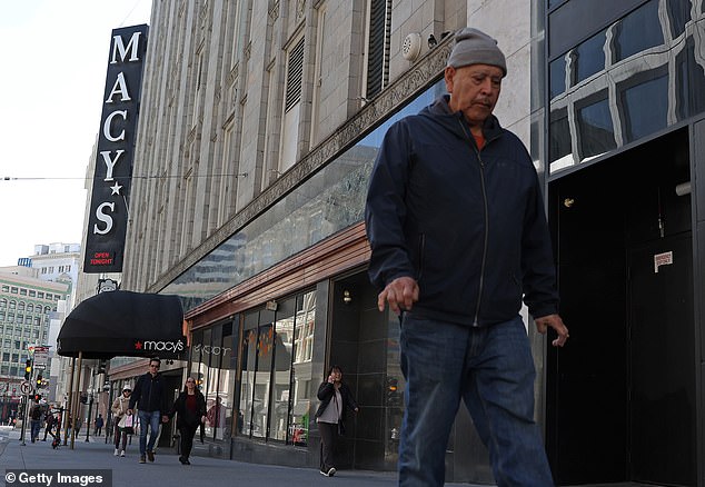 Pedestrians walk past the iconic Macy's flagship store in Union Square in downtown San Francisco, which has been earmarked for closure.  The once-thriving downtown has seen more than a dozen stores close due to a lack of foot traffic, crime and rampant drug use in the area.
