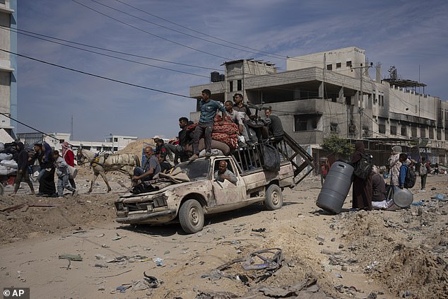 Palestinians drive and walk through the destruction following an Israeli air and ground offensive in Khan Younis.