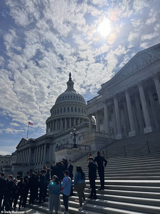 Congressional aides stand on the steps of the Senate and look toward the sun for a glimpse of the eclipse.