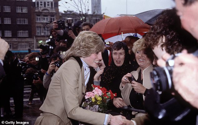 Diana, Princess of Wales, braves wet and windy weather to meet the crowd waiting to see her outside Capital Radio in London, 1982.