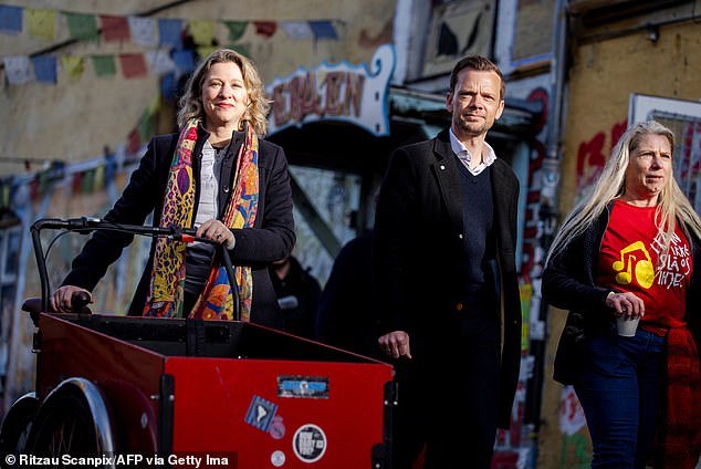 Copenhagen Mayor Sophie Haestorp Andersen (left) and Justice Minister Peter Hummelgaard arrive as Christiania residents unearth the cobblestones of Pusher Street together.