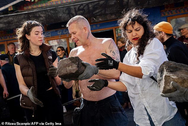 Residents of the Christiania neighborhood walk over a cobblestone unearthed on Pusher Street