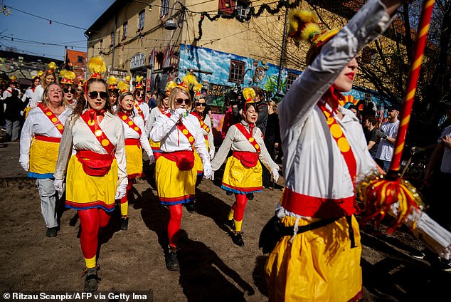 A band of women parades on Pusher Street in Copenhagen, Denmark, on April 6, after residents of the Christiania neighborhood dug up cobblestones to officially mark the closure of the street.