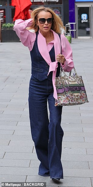 She wore a chic baby pink blouse with a denim vest and matching jeans, paired with a floral Christian Dior bag.