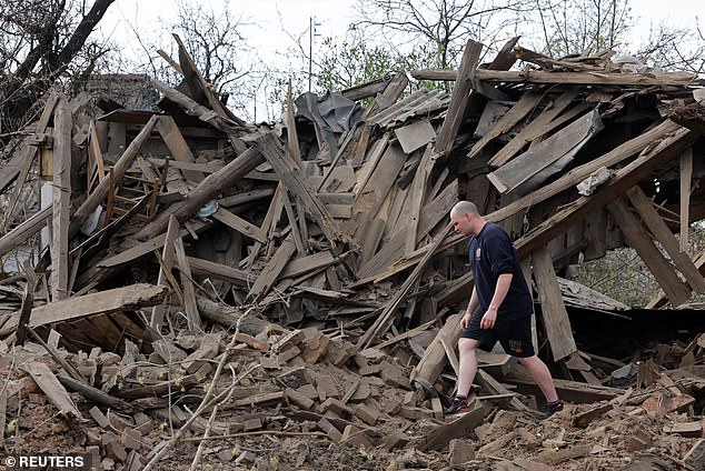 A local resident walks among the ruins of a house destroyed by the recent bombing, which Russian-installed local authorities called a Ukrainian military attack.